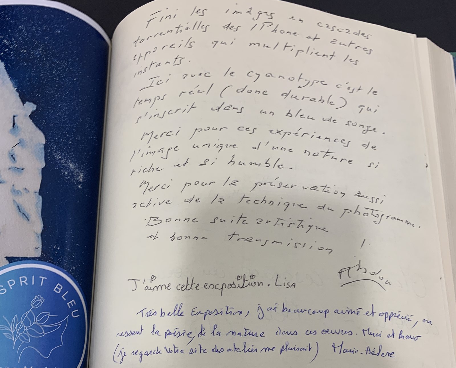 Page manuscrite du livre d'or du Songe Bleu, face à l'affiche de l'exposition et au macaron L'Esprit Bleu